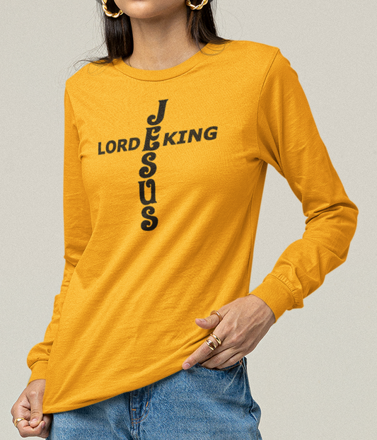 Woman wearing a gold long-sleeve t-shirt with black text 'Jesus Lord King' in the shape of a cross