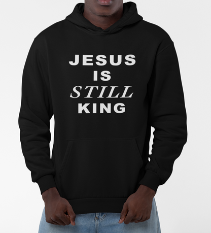 Person wearing a black hoodie with 'JESUS IS STILL KING' text on a white background