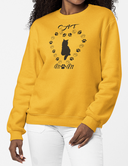 Woman wearing a gold sweatshirt with a black cat design on a white background