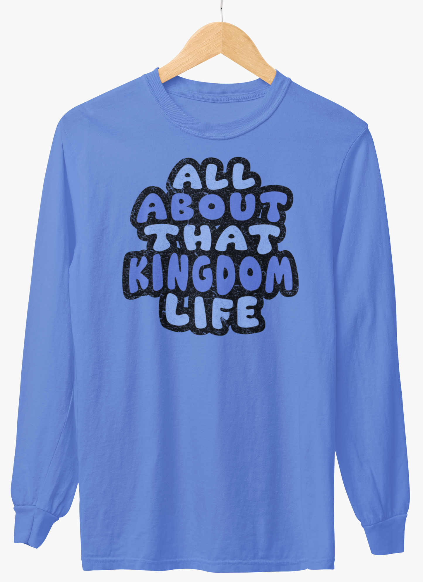 Carolina blue long-sleeve shirt with 'All About That Kingdom Life' distressed text on a hanger against a white background
