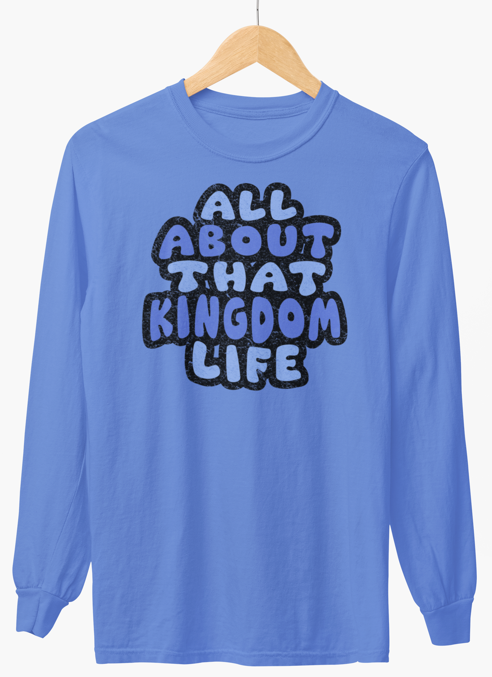 Carolina blue long-sleeve shirt with 'All About That Kingdom Life' distressed text on a hanger against a white background
