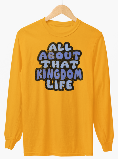 Gold  long-sleeve shirt with distressed text 'All About That Kingdom Life' on a hanger against a white background