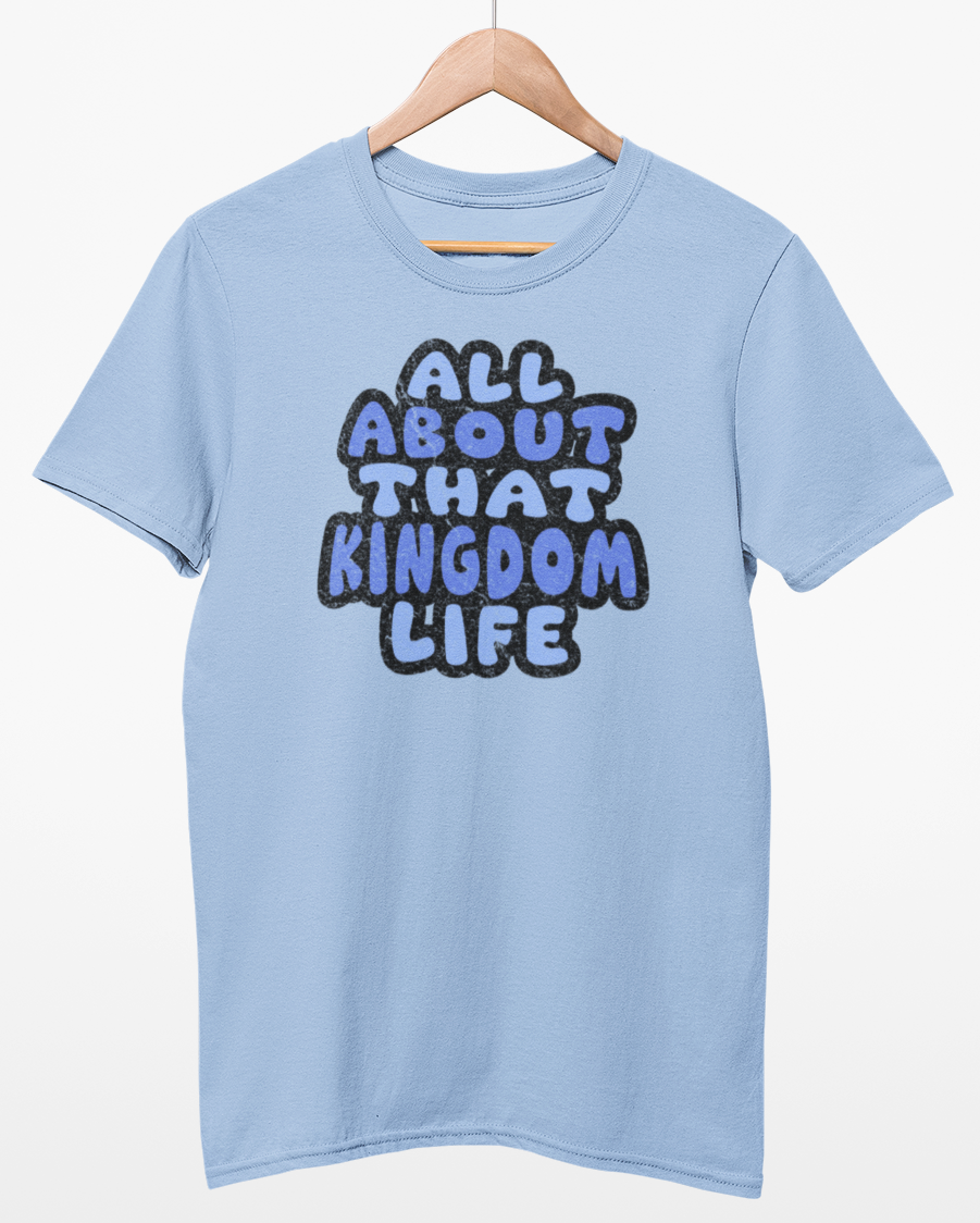 Light blue t-shirt with 'All About That Kingdom Life' distressed text on a hanger against a white background