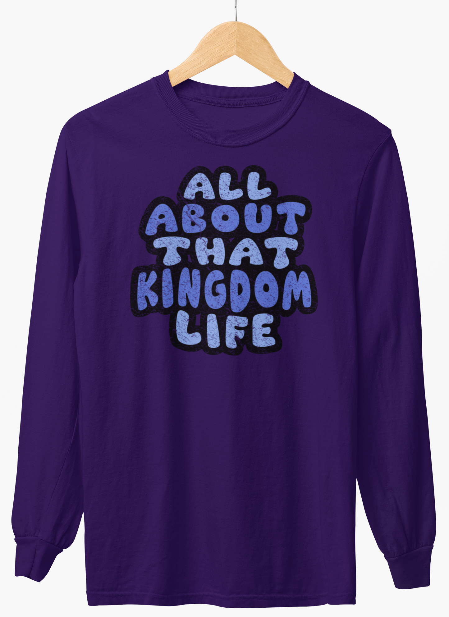 Purple long-sleeve shirt with 'All About That Kingdom Life' distressed text on a hanger against a white background