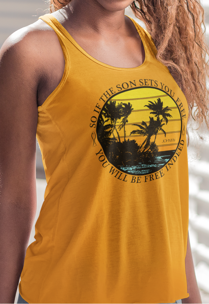 Woman wearing a gold women's racerback tank top with a palm tree design against a distressed sunset background