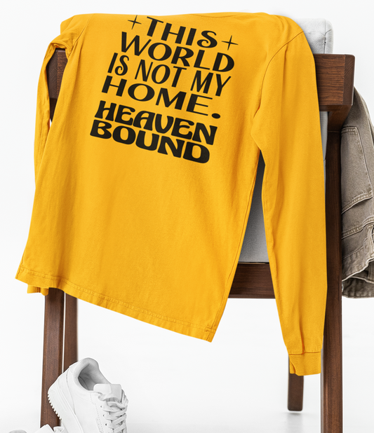 Gold long-sleeve t-shirt with black text 'THIS WORLD IS NOT MY HOME HEAVEN BOUND'